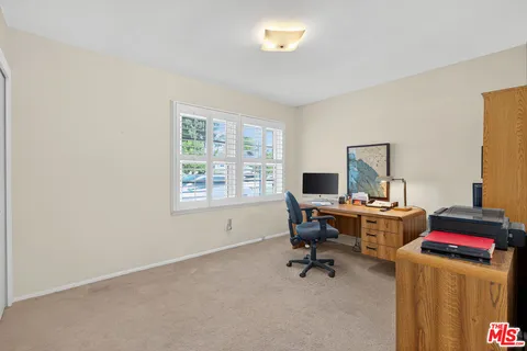 a view of a workspace with furniture and a window