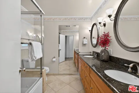a bathroom with a granite countertop sink a mirror and a shower
