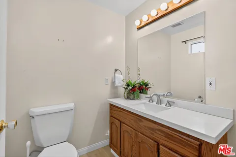 a bathroom with a sink mirror vanity and toilet