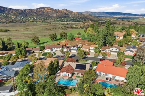 an aerial view of residential houses with outdoor space and river