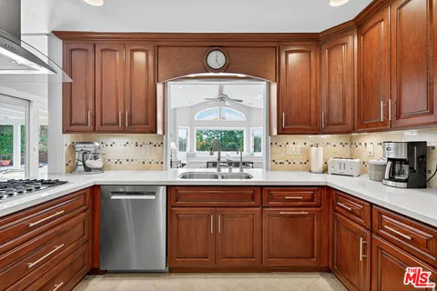 a kitchen with a sink a stove cabinets and wooden floor
