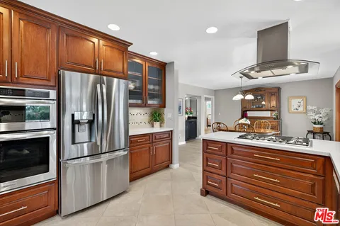 a kitchen with stainless steel appliances granite countertop a refrigerator and a stove