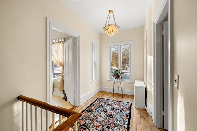 a view of a hallway with wooden floor and a livingroom