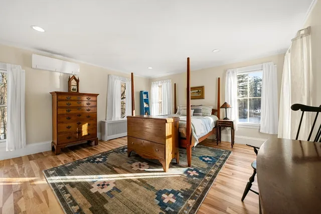 a living room with furniture a wooden floor and next to a window