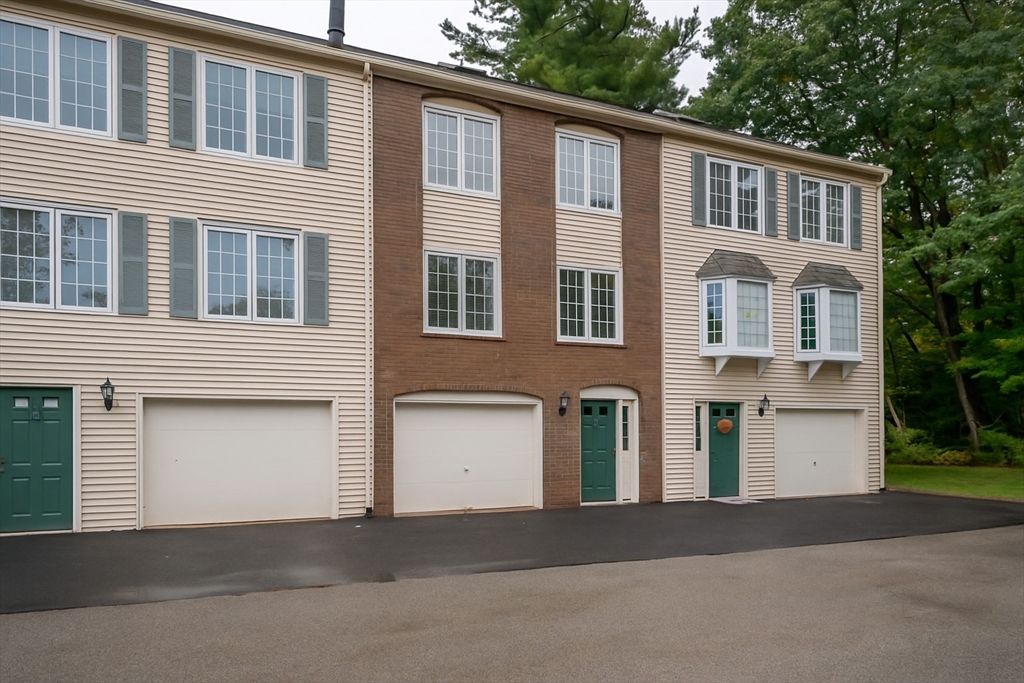 12 Perley Road, Unit 5 Derry, NH 03038 - Photo 1 of 21 a front view of a house with a yard and garage