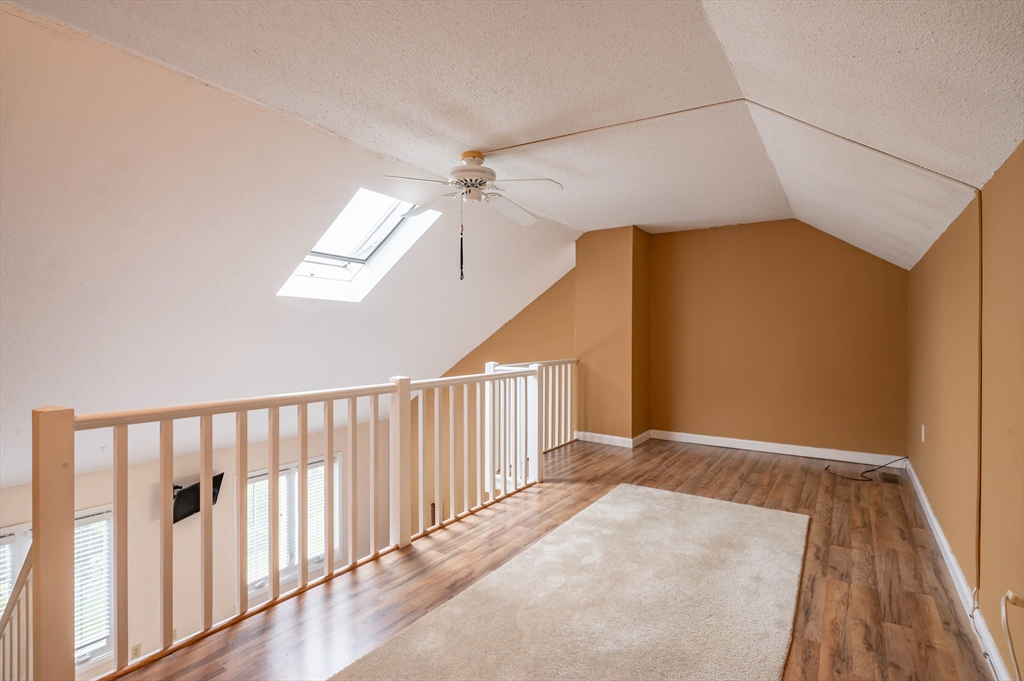 12 Perley Road, Unit 5 Derry, NH 03038 - Photo 16 of 21 a view of a hallway with wooden floor and chandelier