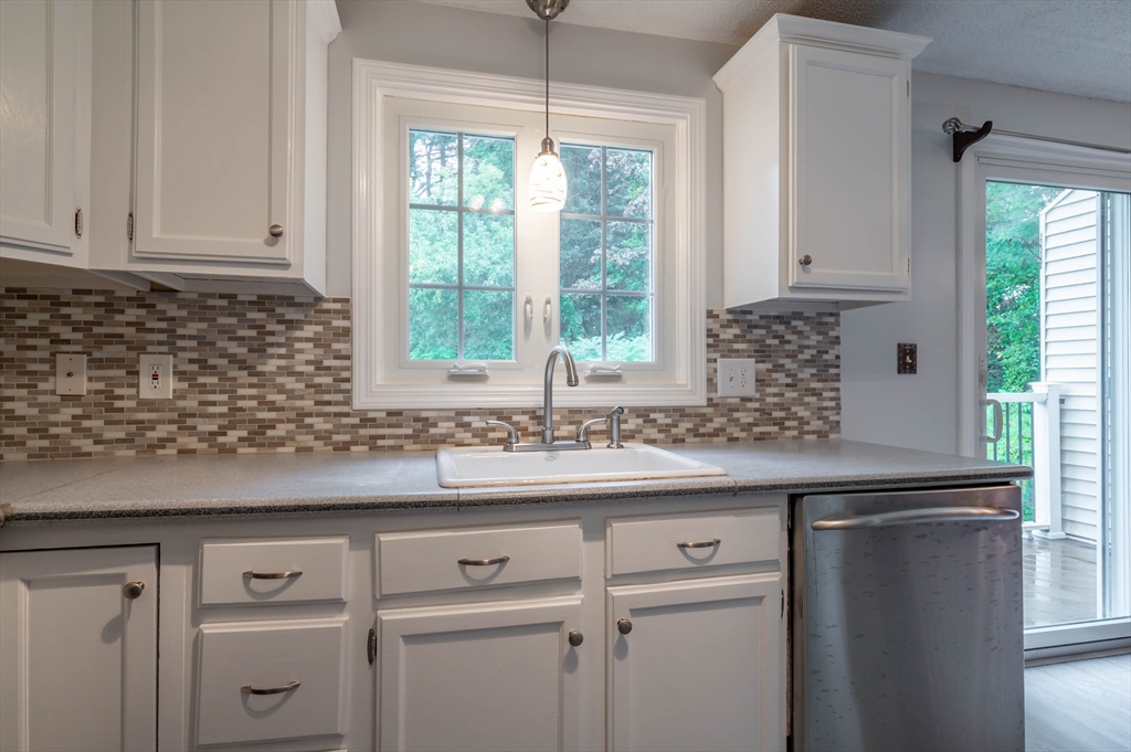 12 Perley Road, Unit 5 Derry, NH 03038 - Photo 5 of 21 a kitchen with white cabinets and a window