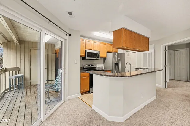 a kitchen with stainless steel appliances granite countertop a refrigerator a stove and a sink