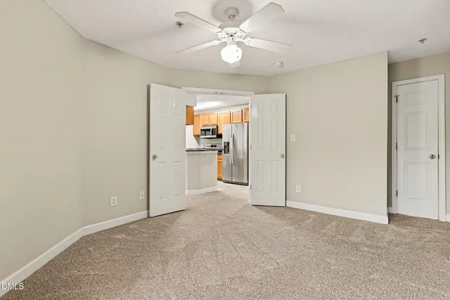 an empty room with fan and windows