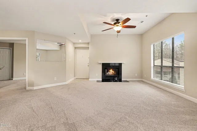 an empty room with windows and fireplace