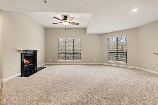 a view of an empty room with a fireplace and a window
