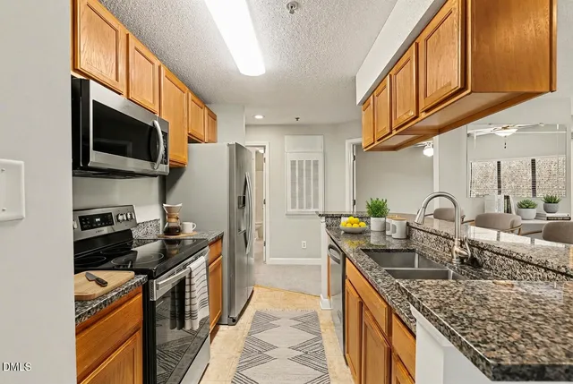 a kitchen with stainless steel appliances granite countertop a stove a sink and a microwave