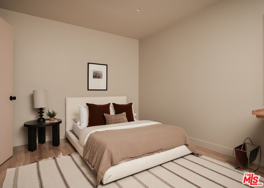 775 San Rafael Terrace Pasadena, CA 91105 - Photo 20 of 56 a bedroom with a bed and wooden floor