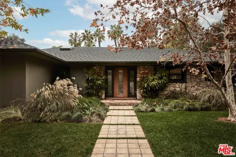 a front view of a house with a garden