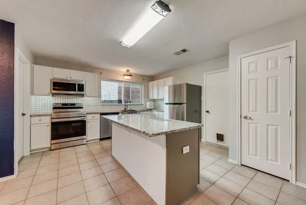 a kitchen with stainless steel appliances granite countertop a stove a sink and a refrigerator