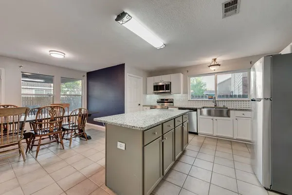 a kitchen with granite countertop cabinets a counter top space and stainless steel appliances