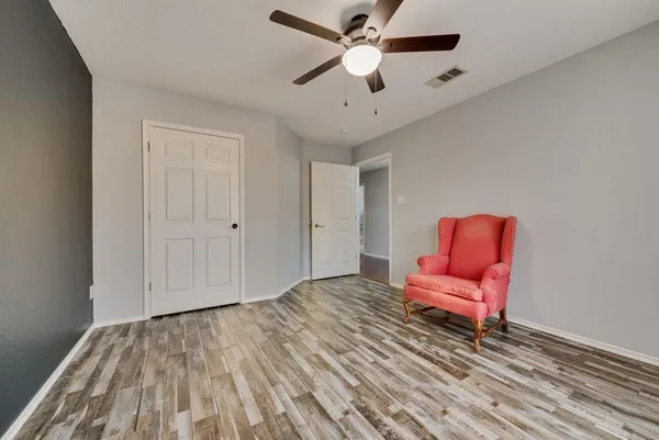 a view of a room with wooden floor a ceiling fan and windows