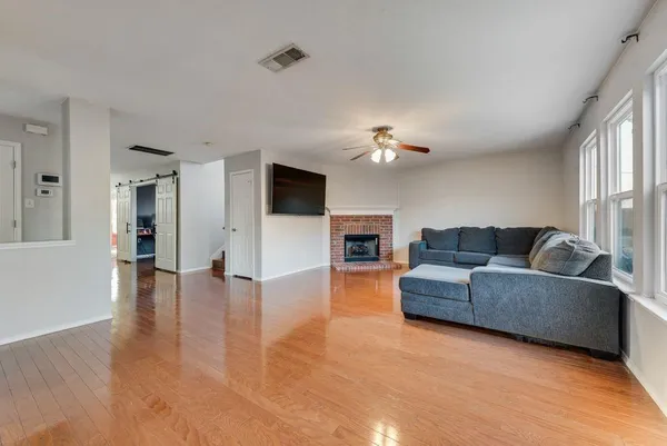 a living room with furniture and a wooden floor