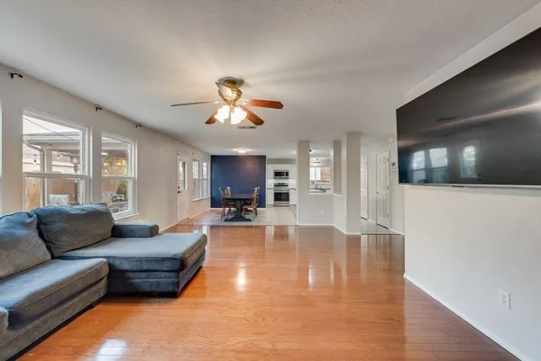 a living room with furniture a flat screen tv and kitchen view