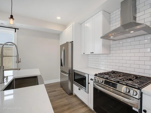 a kitchen with granite countertop a stove and a refrigerator