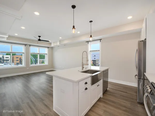 a kitchen with a stove a sink a window and wooden floor