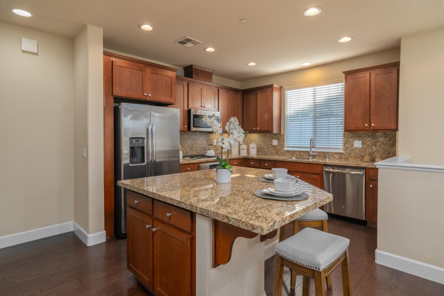 545 Holthouse Terrace Sunnyvale, CA 94087 - Photo 6 of 24 a kitchen with stainless steel appliances granite countertop a kitchen island a stove a table and chairs