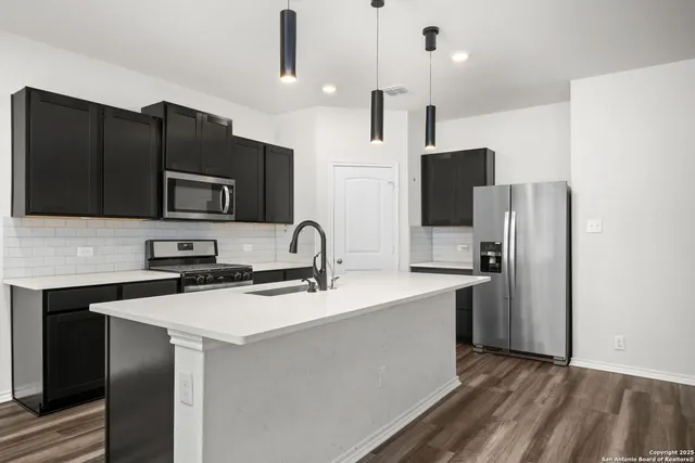 a kitchen with stainless steel appliances a refrigerator stove and microwave