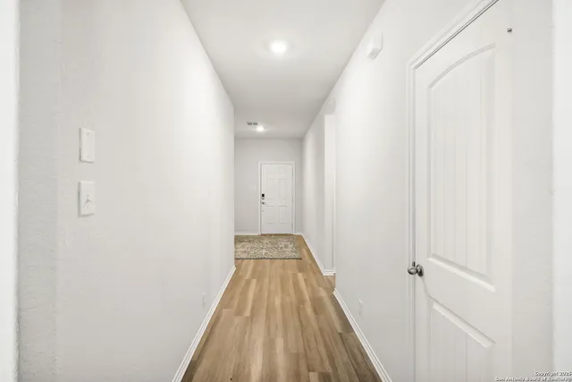 a view of a hallway with wooden floor