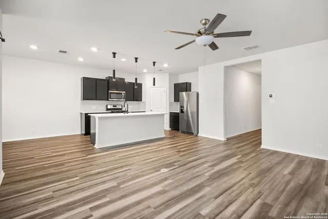 a view of a kitchen with a sink and a refrigerator