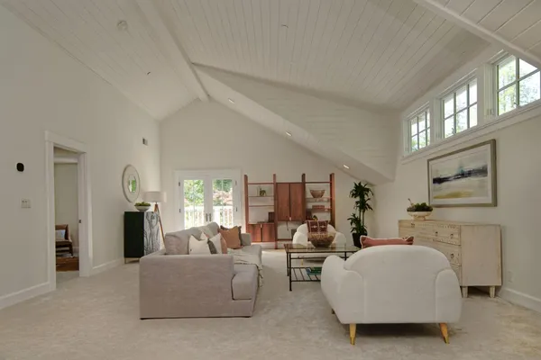 a spacious bedroom with a bed a couch and a painting on the wall