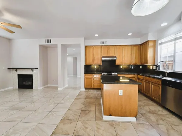 a kitchen with stainless steel appliances granite countertop a stove a sink and a refrigerator