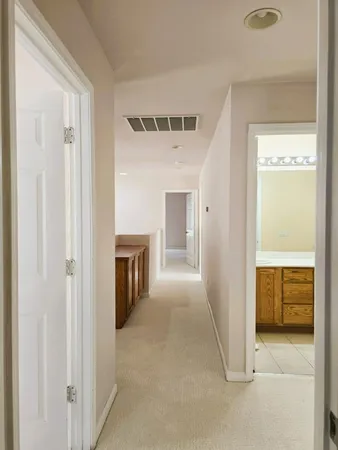 a view of a hallway with a kitchen space and a sink