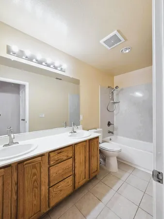 a bathroom with a double vanity sink mirror and toilet