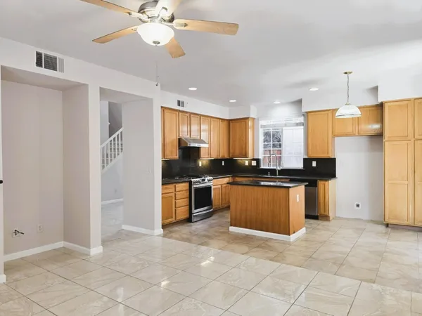 a kitchen with stainless steel appliances granite countertop a refrigerator and a stove top oven