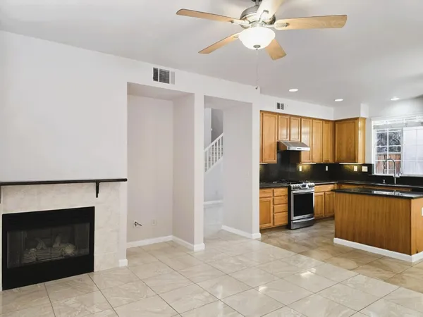 a kitchen with stainless steel appliances granite countertop a refrigerator a sink a stove top oven and a sink