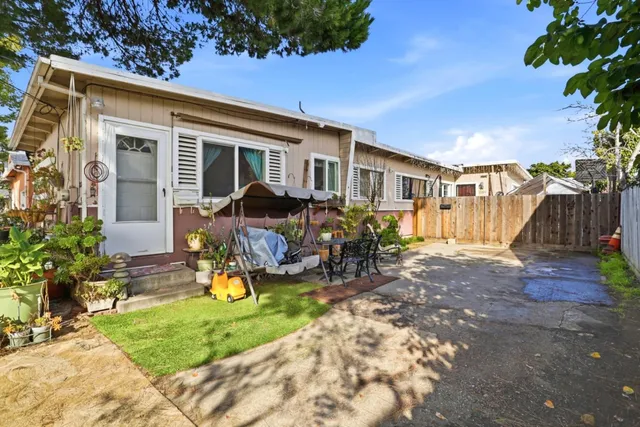 a view of a house with backyard sitting area and garden