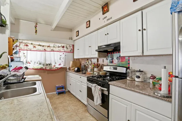 a kitchen with stainless steel appliances granite countertop a sink dishwasher stove and cabinets