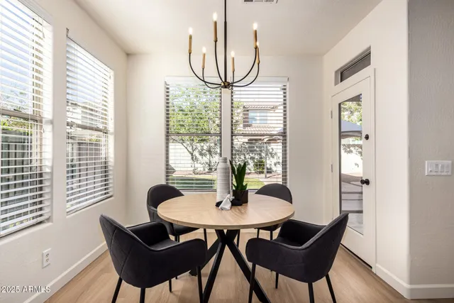 a kitchen with stainless steel appliances granite countertop a stove a sink a microwave a dining table and chairs