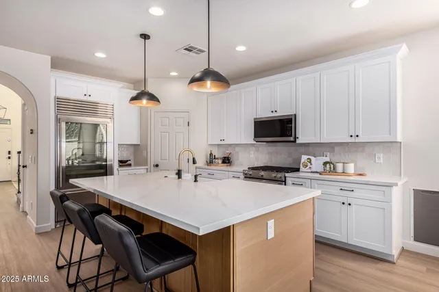 a kitchen with stainless steel appliances a stove microwave and sink