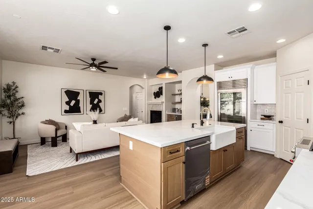 a kitchen with stainless steel appliances a stove center island a dining table and chairs