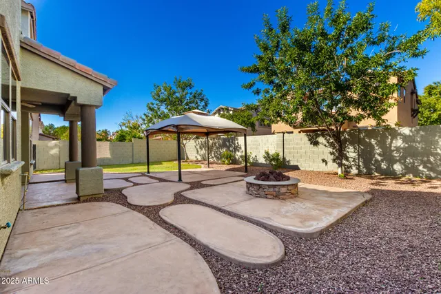 a view of pool with lawn chairs under an umbrella