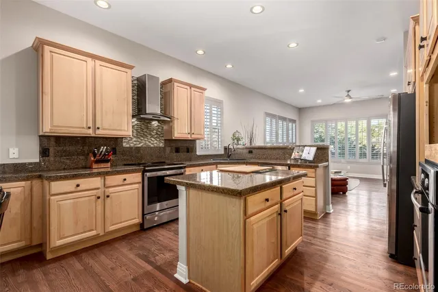 a kitchen with kitchen island granite countertop a stove and a sink