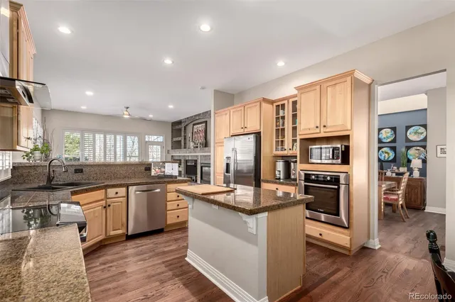 a large kitchen with stainless steel appliances granite countertop a stove refrigerator and a sink