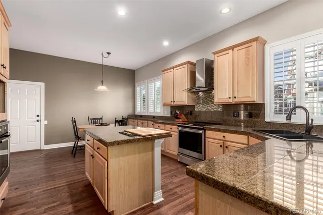 a kitchen with stainless steel appliances granite countertop a stove a sink dishwasher and a microwave oven with wooden floor