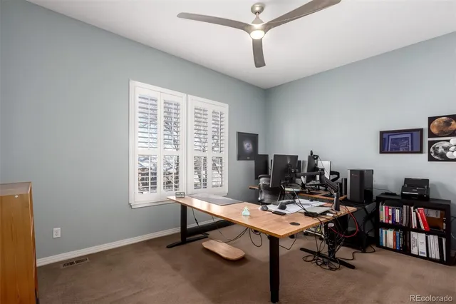 a view of a workspace with furniture and a window
