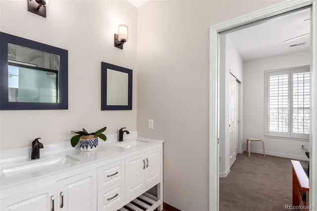 a bathroom with double vanity sink a mirror and window