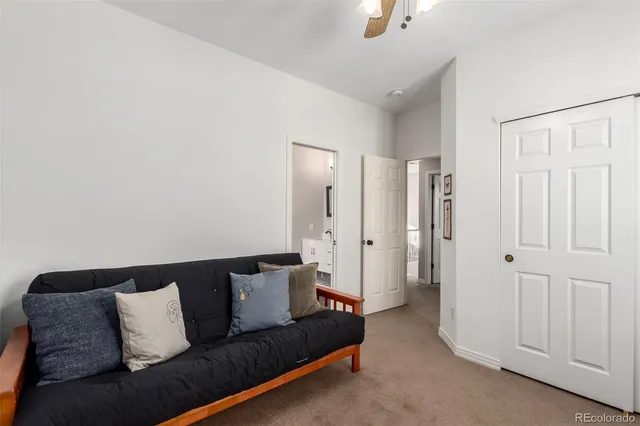 a living room with furniture and a ceiling fan