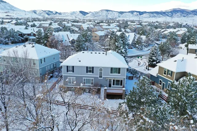 an aerial view of a house with a yard and mountain view in back