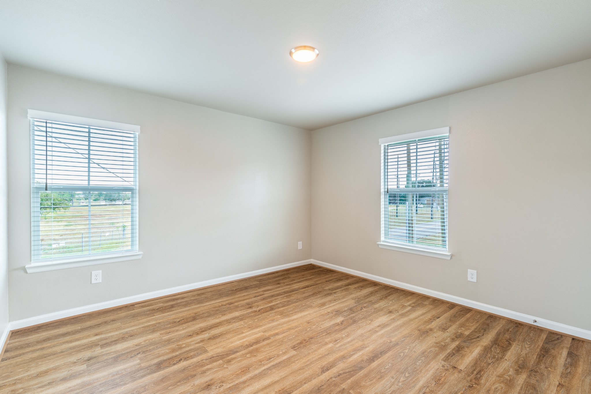 203 Park Place Circle, Unit D Waller, TX 77484 - Photo 21 of 29 an empty room with wooden floor and windows
