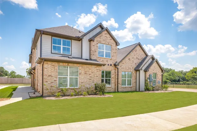 a front view of a house with a garden and yard
